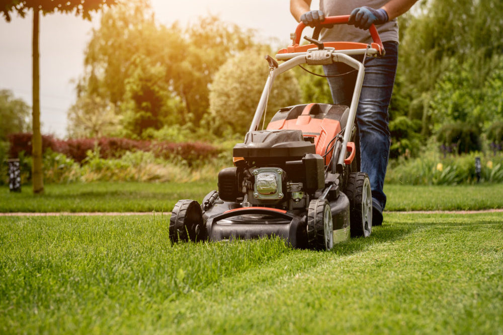 Gardener mowing the lawn. Landscape design.